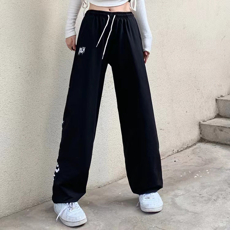 Damen nan locker geschnittene Wide‑Leg Jogginghose mit hohem Bund und markantem Seitenschriftzug Drune