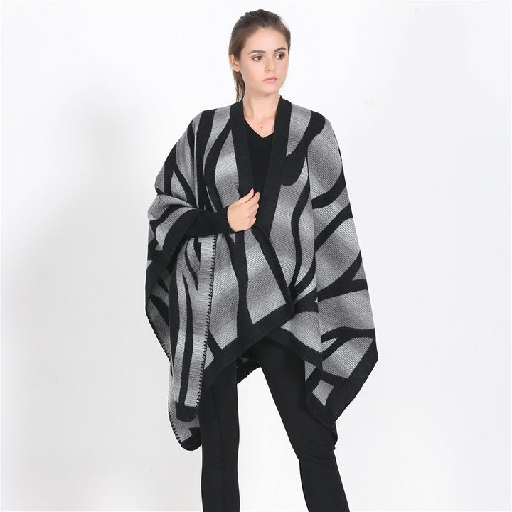 Damen Oversize-Strickcape mit abstrakter Wellenjacquard‑Struktur und kontrastierter Kettelkante Drune