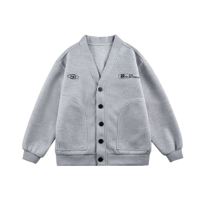 Unisex Boxy-Strickjacke im Waffelstrick mit V-Kragen, durchgehender Knopfleiste und aufgesetzten Rundtaschen Drune