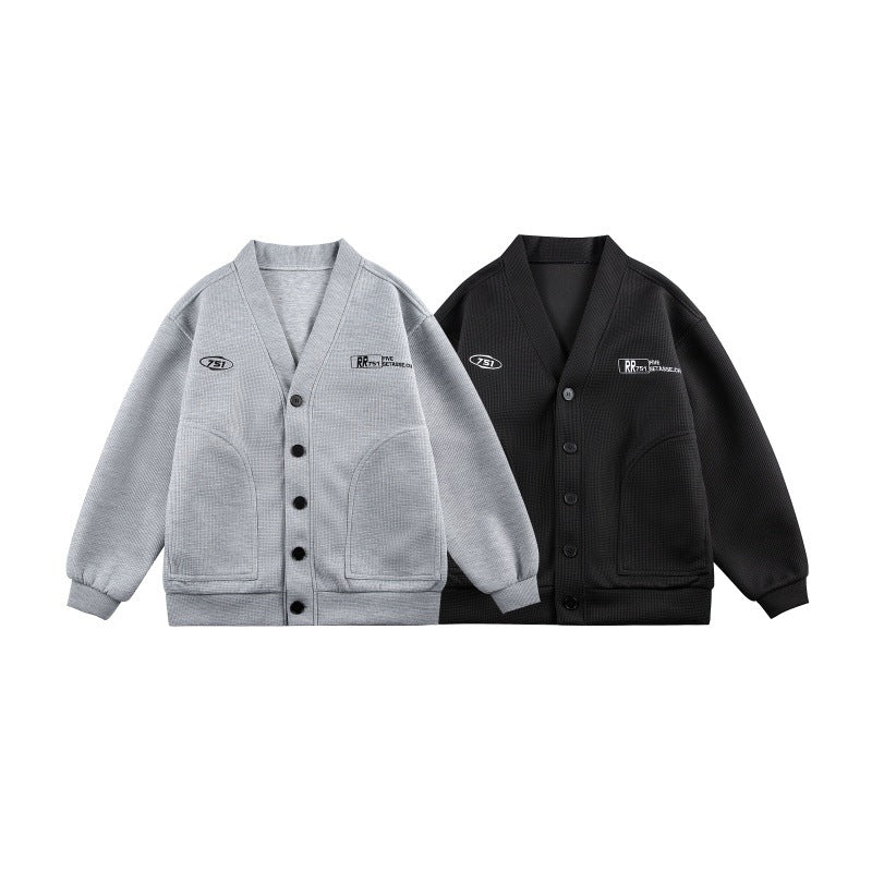 Unisex Boxy-Strickjacke im Waffelstrick mit V-Kragen, durchgehender Knopfleiste und aufgesetzten Rundtaschen Drune