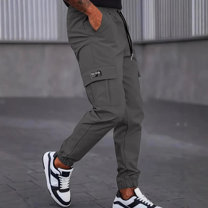 Herren Utility-Cargohose im Joggerstil mit Tunnelzugbund elastischen Beinabschlüssen und Multifachtaschen Drune
