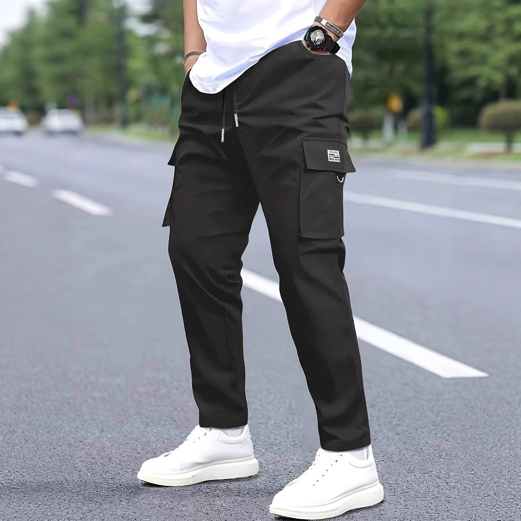 Herren Slim‑Tapered Cargo‑Jogginghose mit Tunnelzugbund, Klappentaschen und Metallringdetail Drune