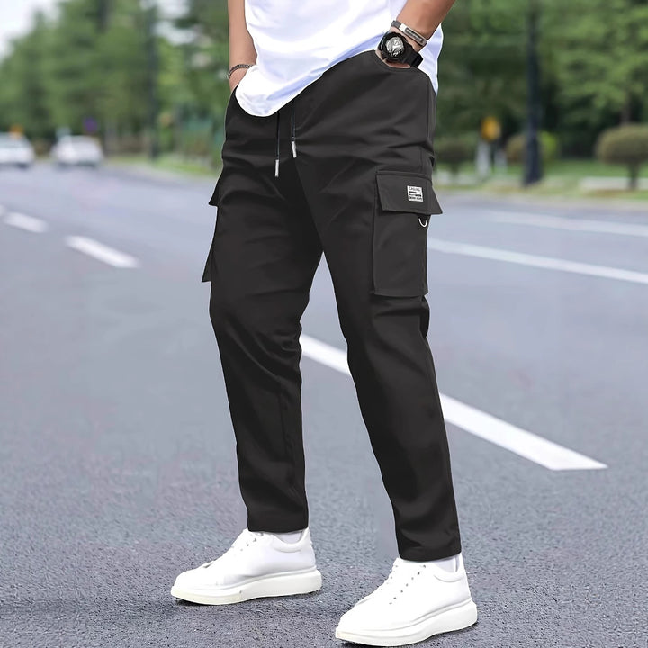 Herren Slim‑Tapered Cargo‑Jogginghose mit Tunnelzugbund, Klappentaschen und Metallringdetail Drune