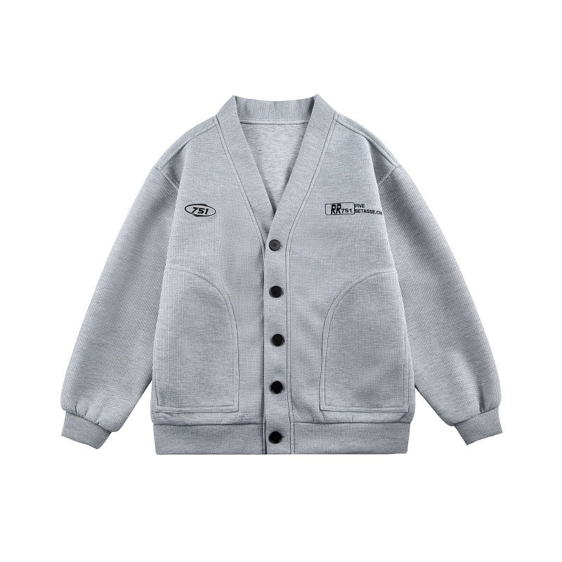 Unisex Boxy-Strickjacke im Waffelstrick mit V-Kragen, durchgehender Knopfleiste und aufgesetzten Rundtaschen Drune