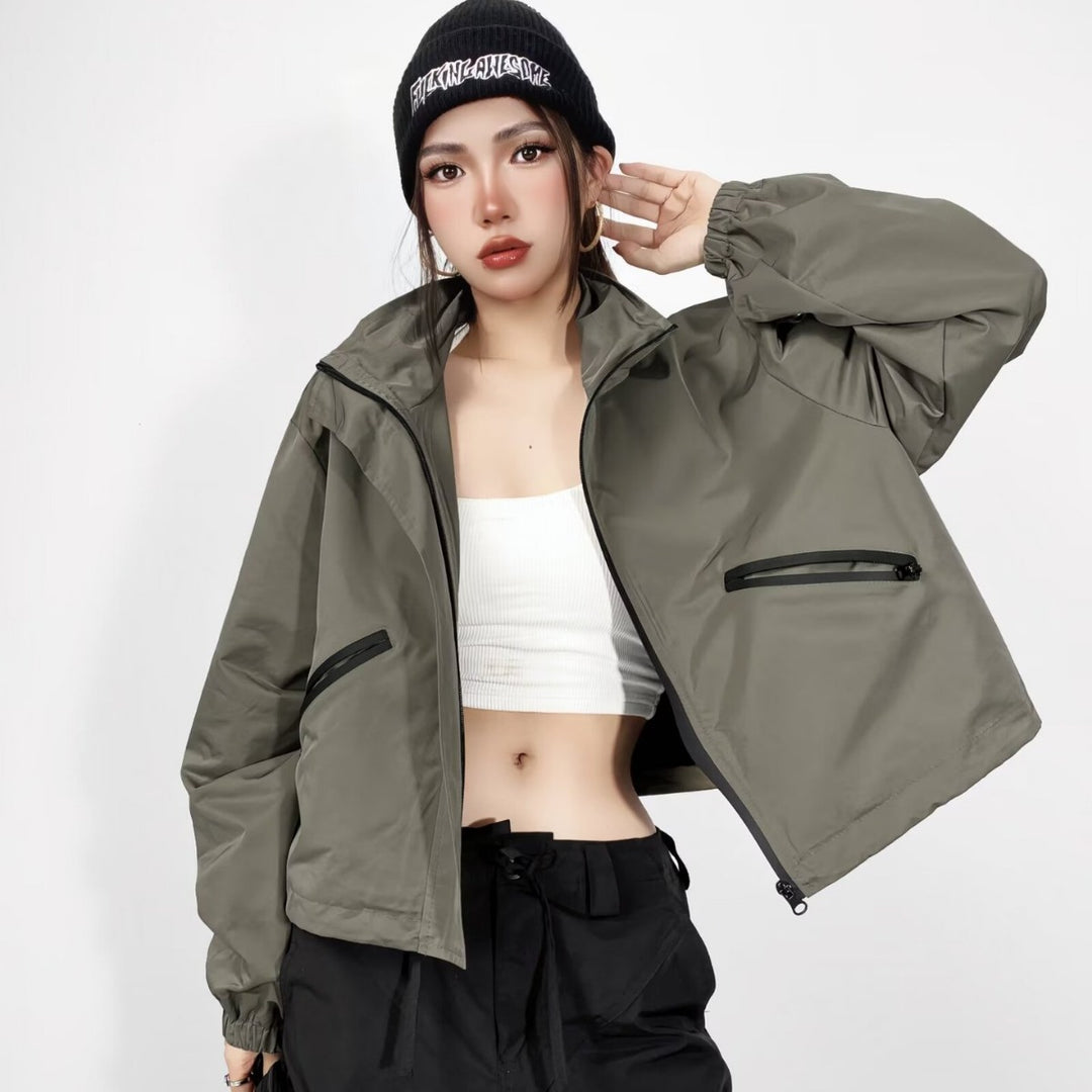 Damen Cropped Regenjacke mit Kapuze, wasserabweisender Tech‑Qualität und schrägen Reißverschlusstaschen Drune
