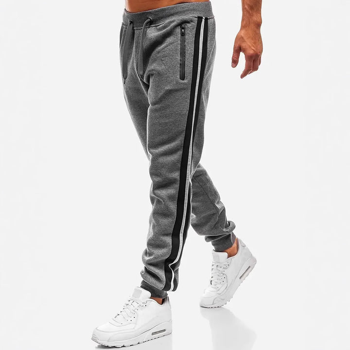 Herren nan schmal zulaufende Fleece-Jogginghose mit zweifarbiger Seitenpaspel und wasserabweisenden Reißverschlusstaschen Drune