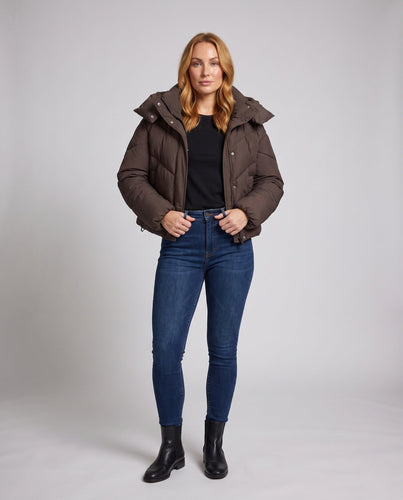 Damen cropped gesteppte Jacke mit hohem Schalkragen, asymmetrischer Zickzack-Steppung und verstellbarem Kordelzugbund.