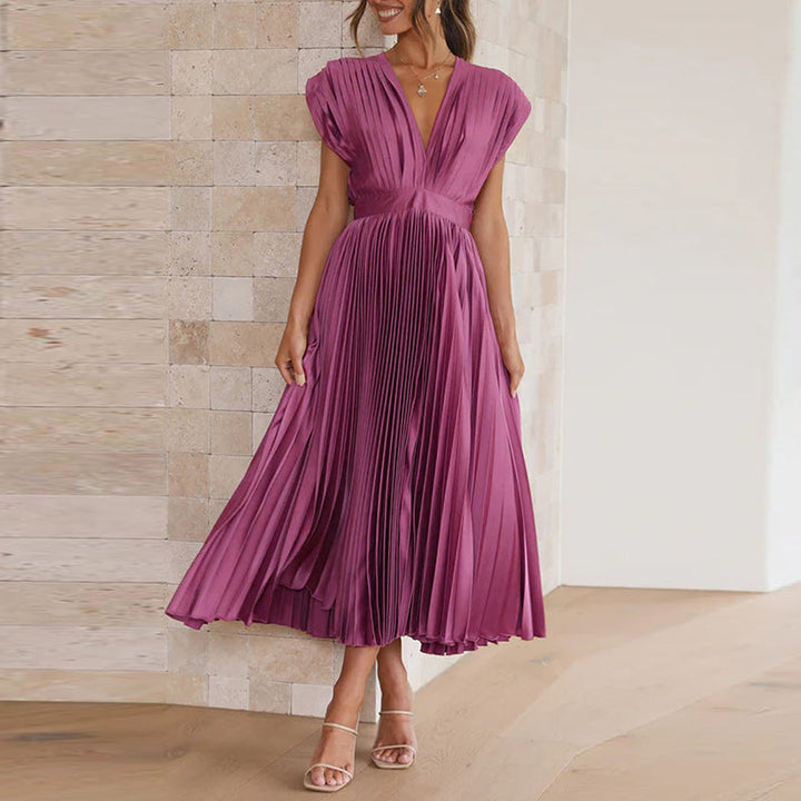 Model in einem paars kleid mit v-ausschnitt, stehend in einem hellen, modernen innenraum